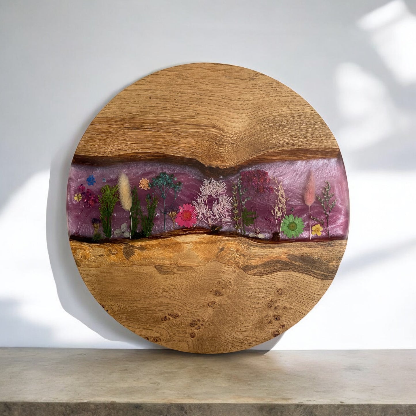 top down view of the floral meadow style table. handmade from character oak and high grade resin it features a pink background, dried flowers set out like a meadow and a clear resin top coat.