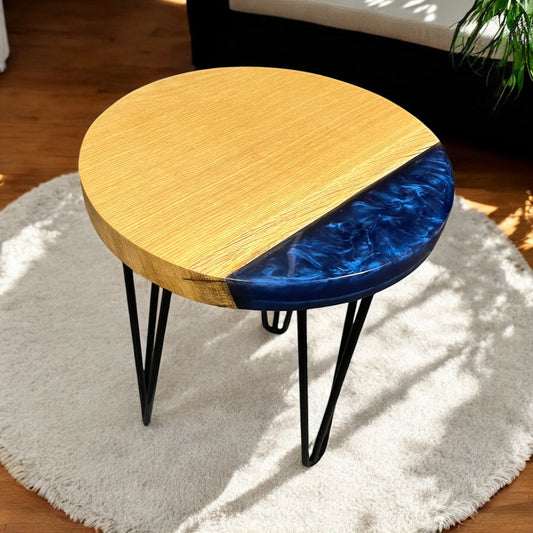A handcrafted oak end table with ocean blue epoxy resin detailing along the front edge, showcasing natural wood grain and a smooth, glossy finish.