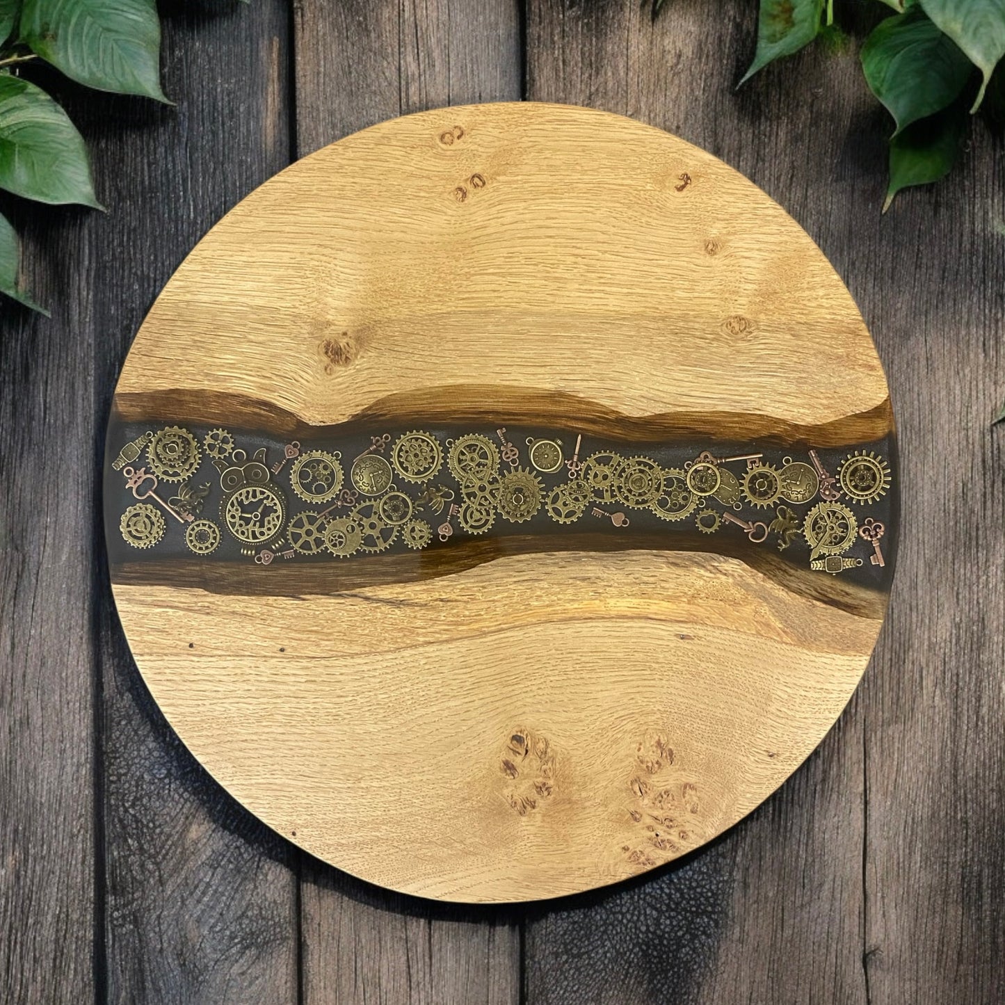 Top-down view of a handcrafted oak and epoxy resin end table featuring an intricate steampunk-inspired design with gears and metallic accents