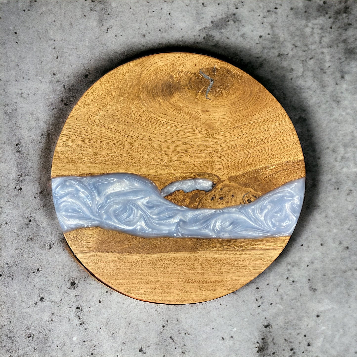 A top-down view of a handcrafted oak and baby blue epoxy resin end table, showcasing the smooth, glossy resin finish and natural wood grain.