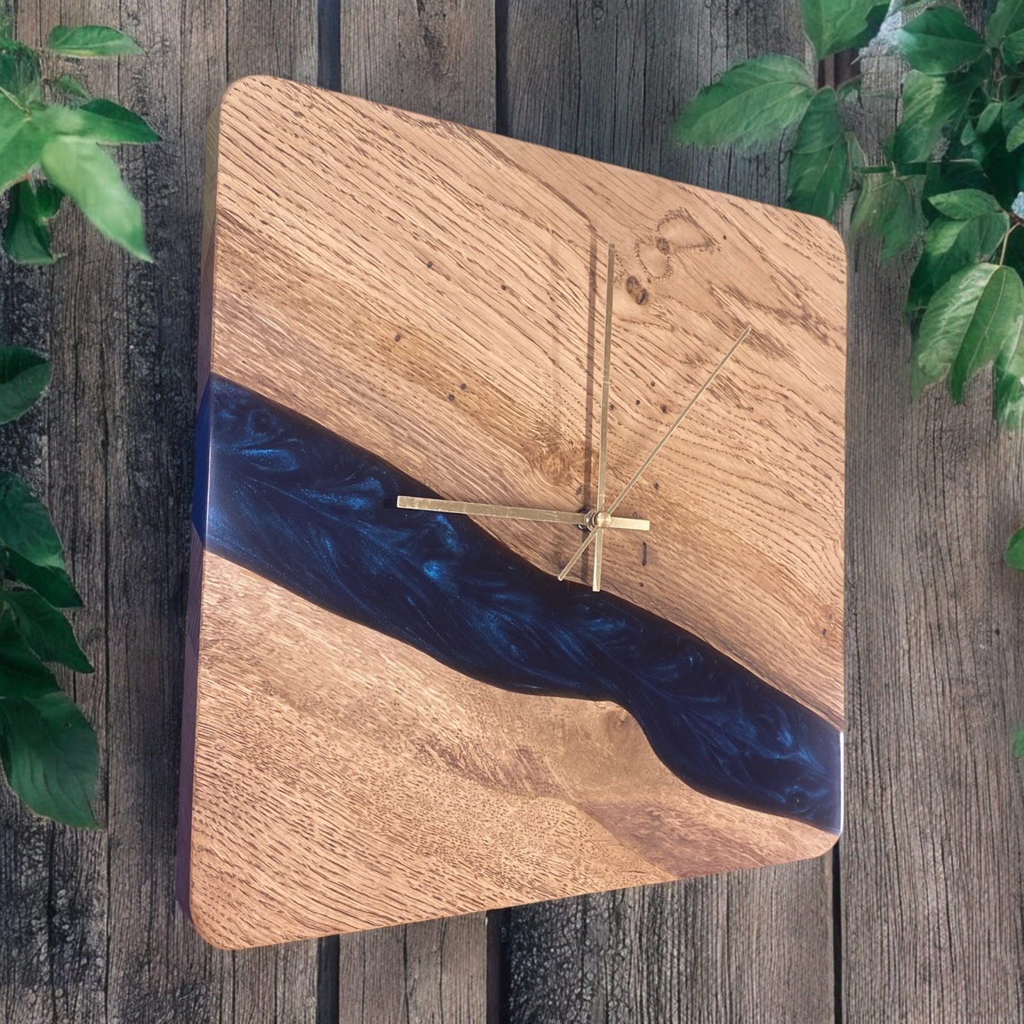 side view of a square oak and astral blue epoxy resin wall clock, showcasing its smooth resin finish and natural wood grain details