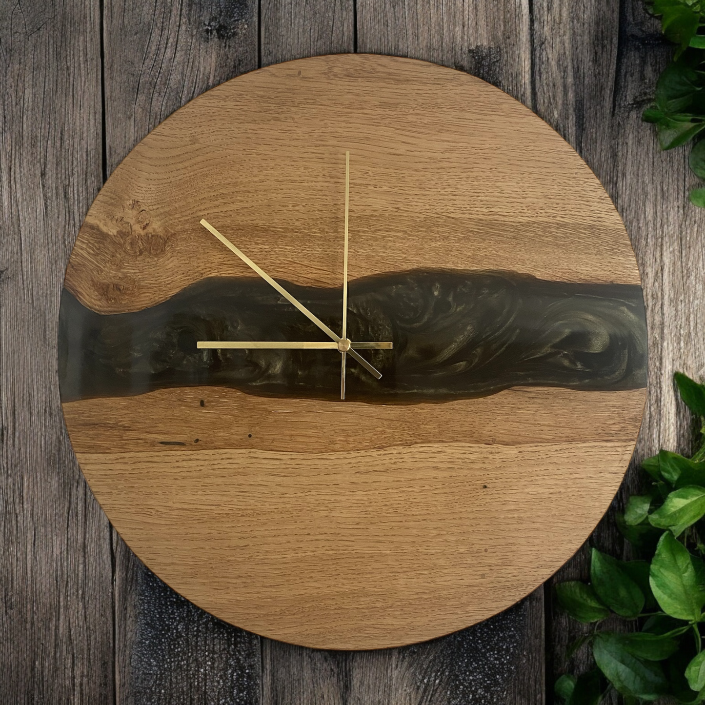 Handmade oak and epoxy resin wall clock with green and black central resin river design, featuring natural wood grain and a sleek modern design