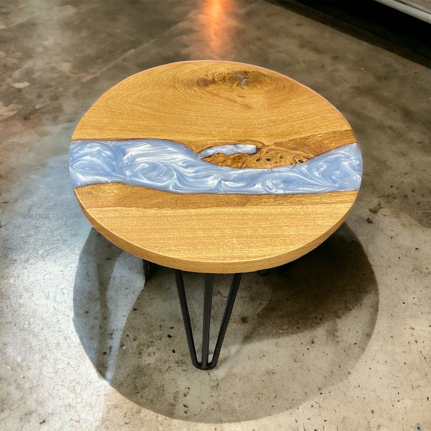 A front-facing image of the oak and baby blue resin end table, supported by sleek black hairpin legs for a modern finish.