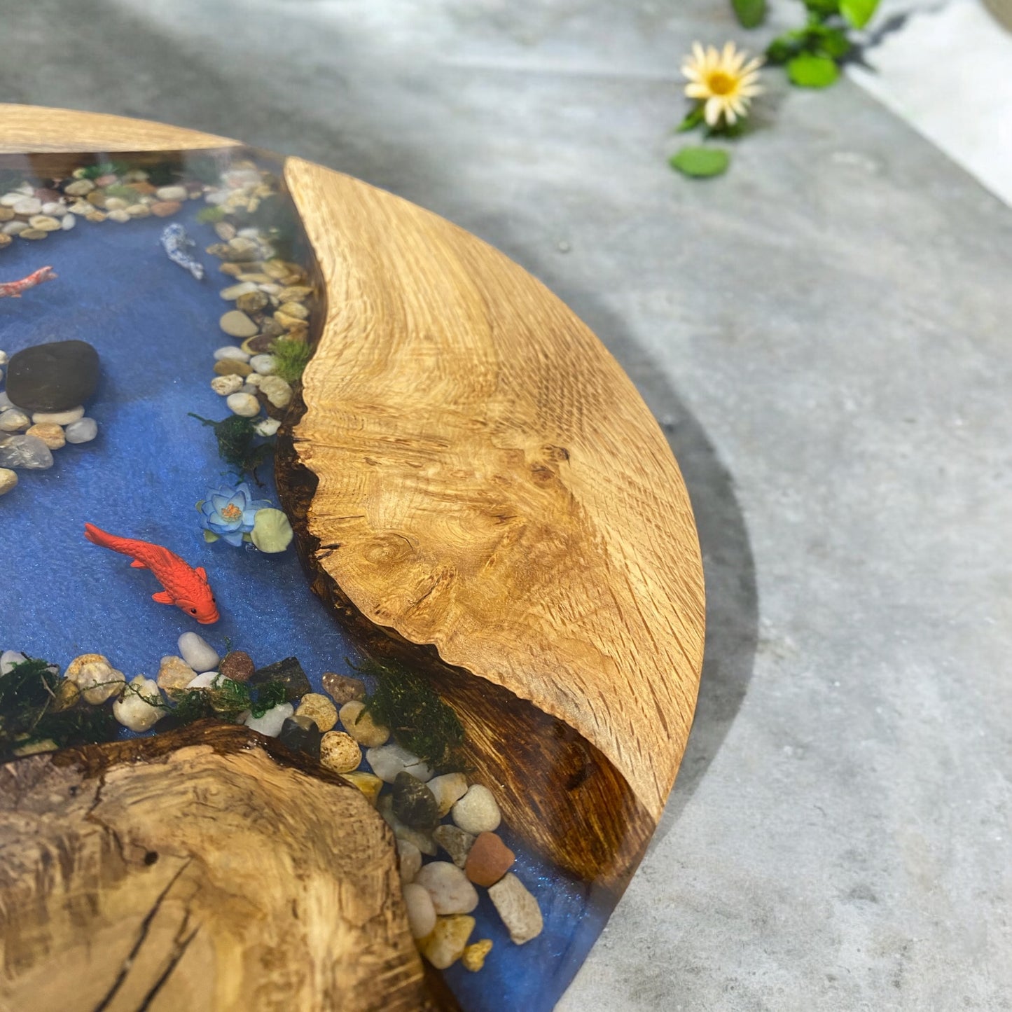 Close-up view of our koi pond resin table, capturing the delicate lily pads and aquatic elements within the epoxy resin.