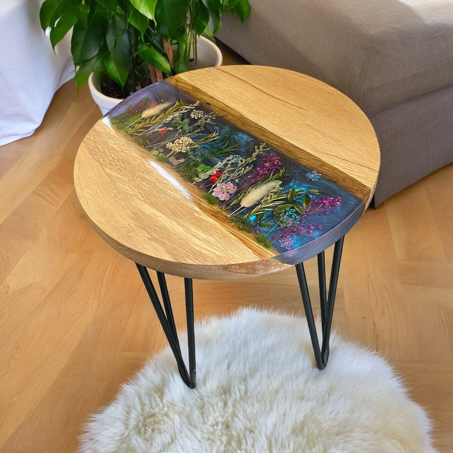 Side angle of a unique floral epoxy resin end table, highlighting the contrast between the warm oak and the iridescent chameleon resin.