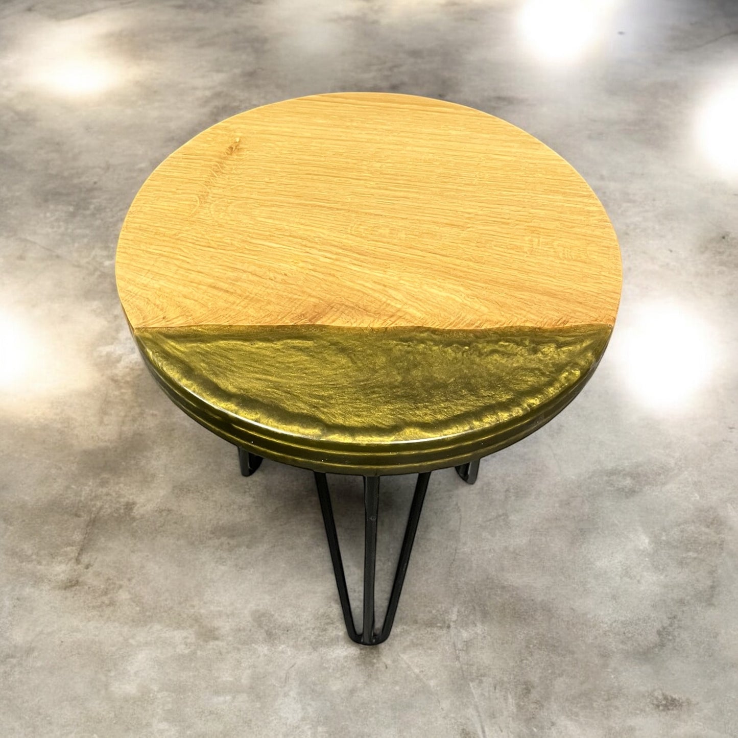 A handmade oak and resin end table with elegant front edge olive gold epoxy, supported by sleek, modern black hairpin legs.
