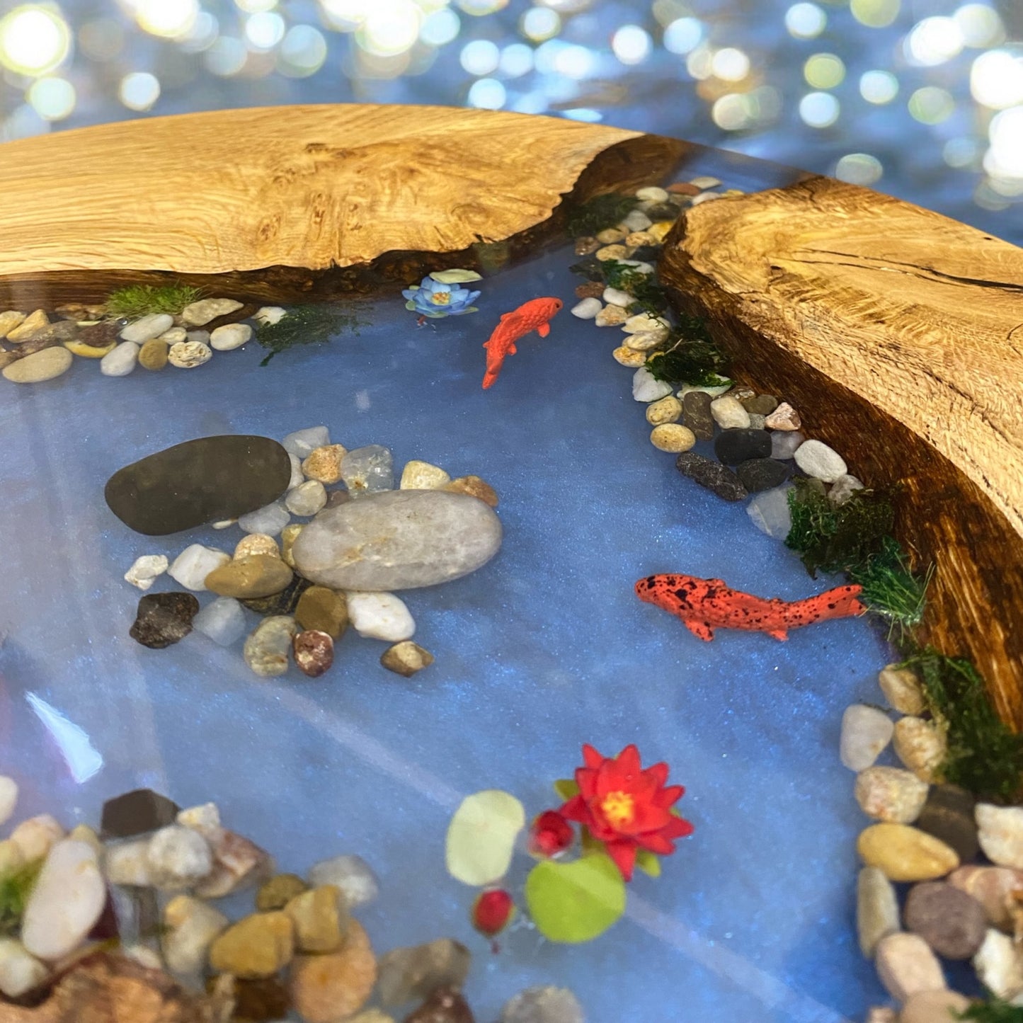 Close-up view of koi pond table highlighting the natural oak wood grain blending seamlessly with the clear resin