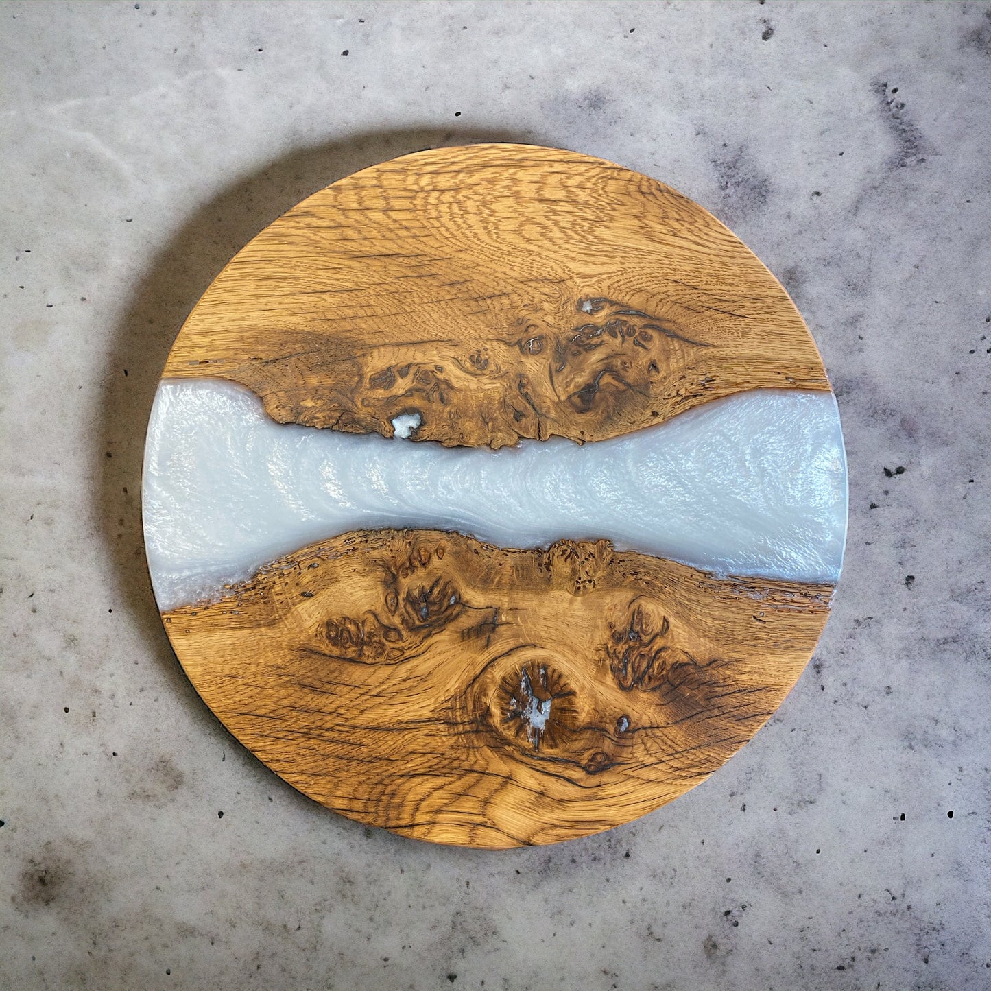 A top-down view of a handcrafted dark oak and snow-white epoxy resin end table, showcasing the striking contrast between the rich wood grain and smooth resin.