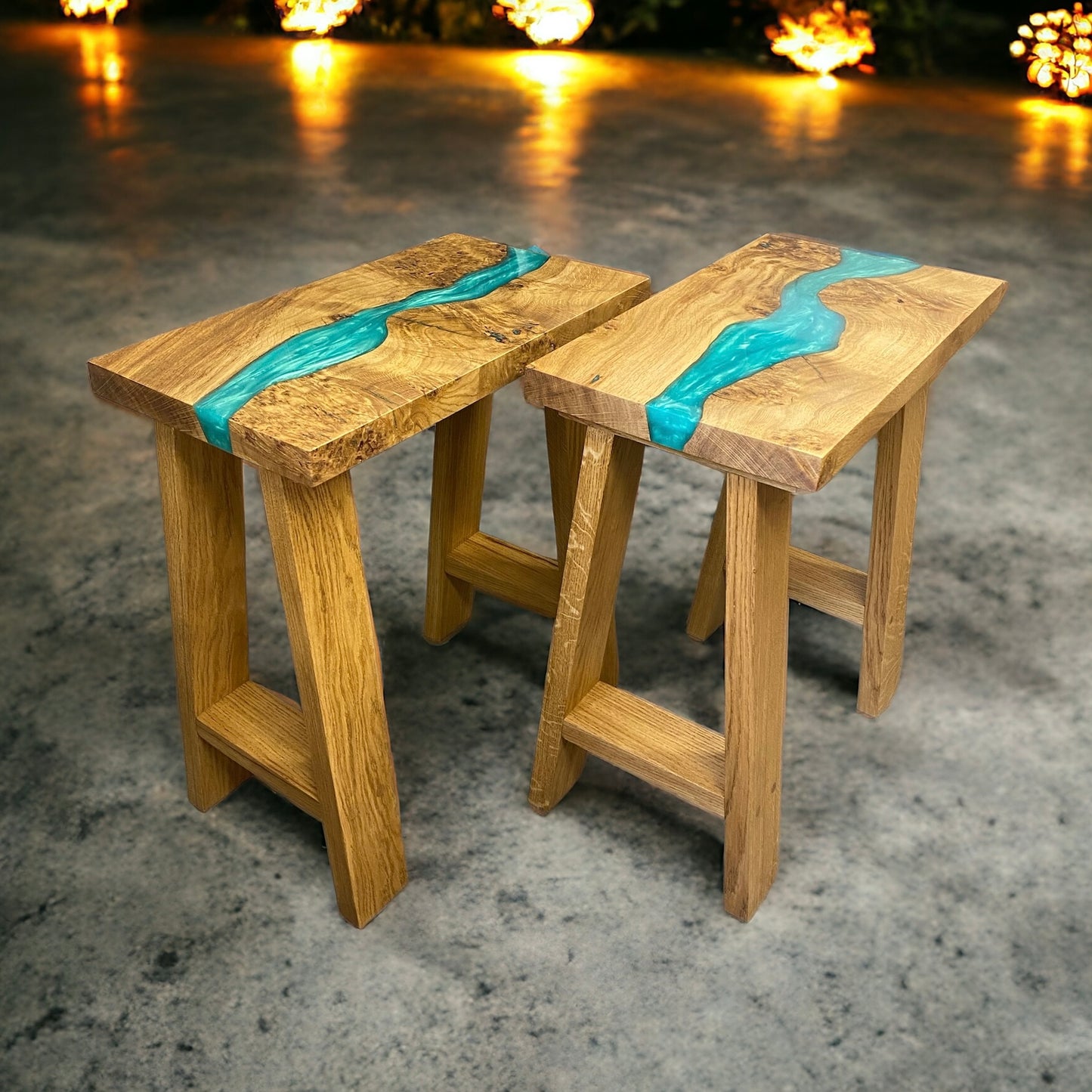 a side view of a pair of teal side tables with resin river table tops and solid oak a frame legs