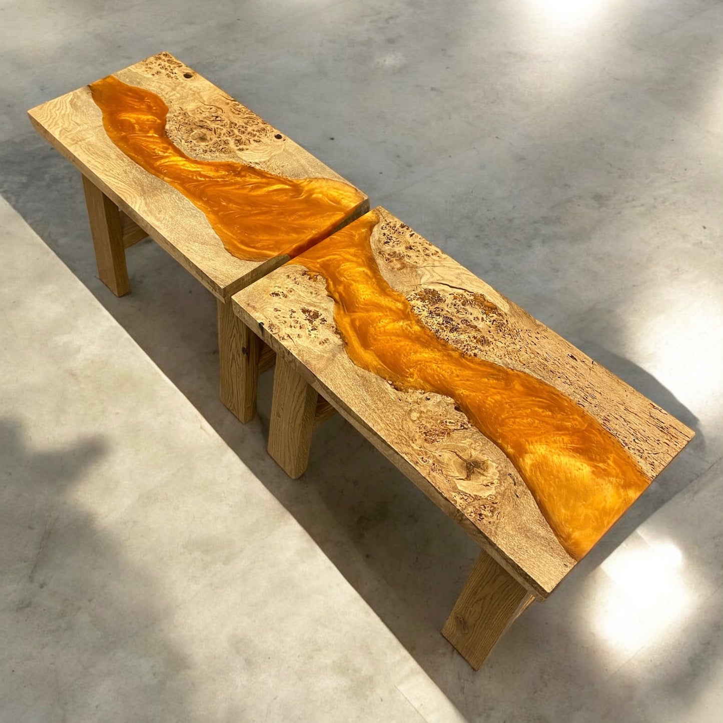 A top view of orange resin river side tables end to end. they have solid oak a from legs