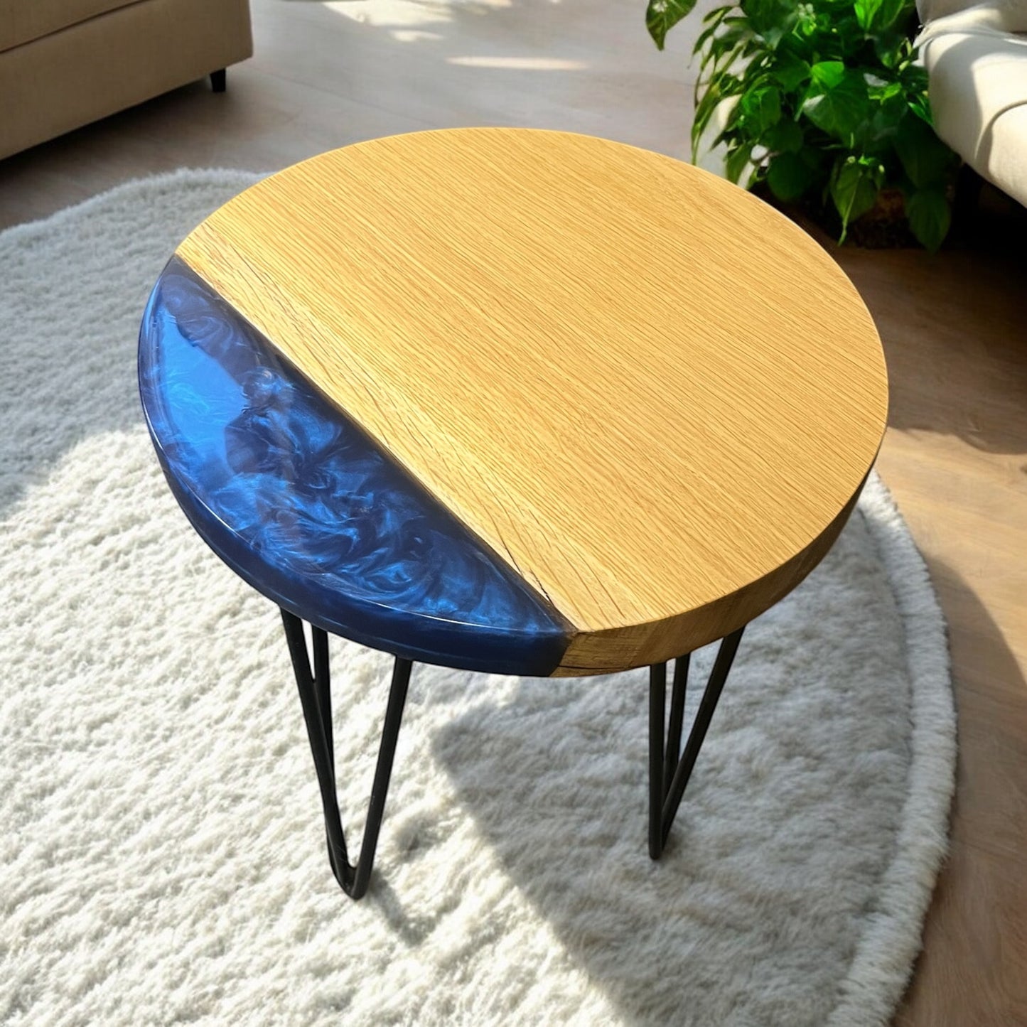 A side angle of the oak and epoxy end table, showing its sturdy black metal hairpin legs and elegant resin design.
