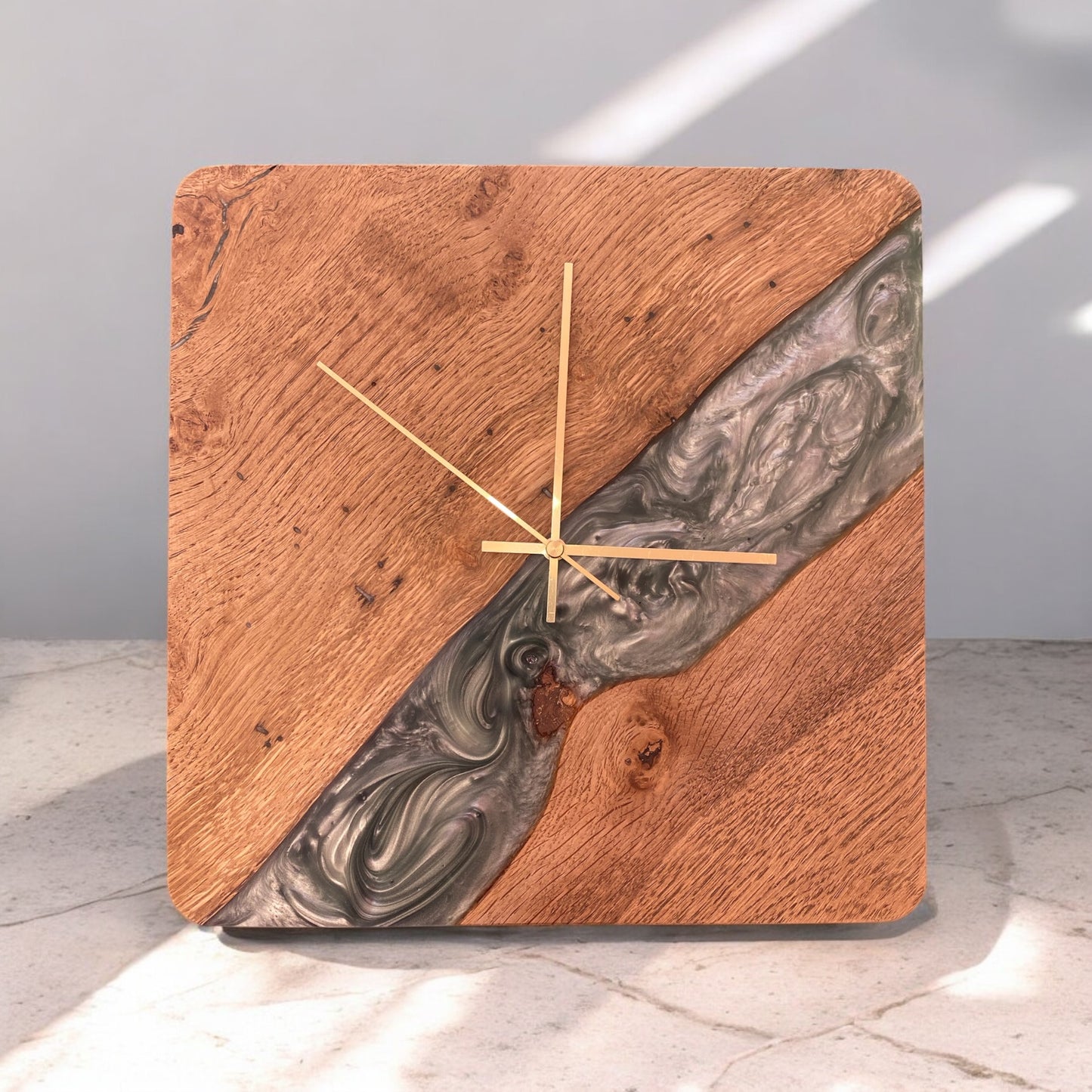 A handcrafted square wall clock made from natural oak with a Sage Green epoxy resin accent, featuring sleek black hands and a minimalist design.