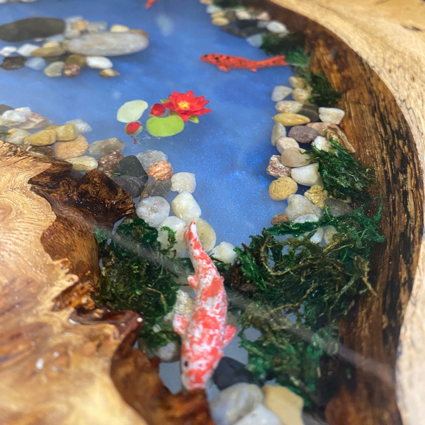 Close-up view of the epoxy resin koi pond design, showcasing the intricate fish details and water-like effect.