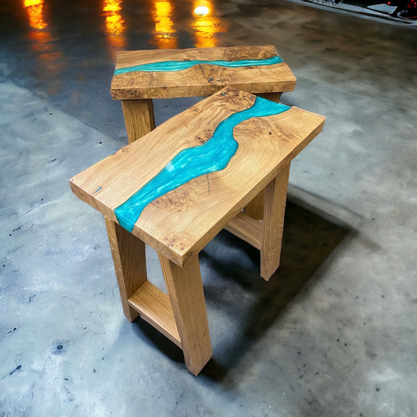 one in front of the other view of two teal resin river tables with solid oak a frame legs