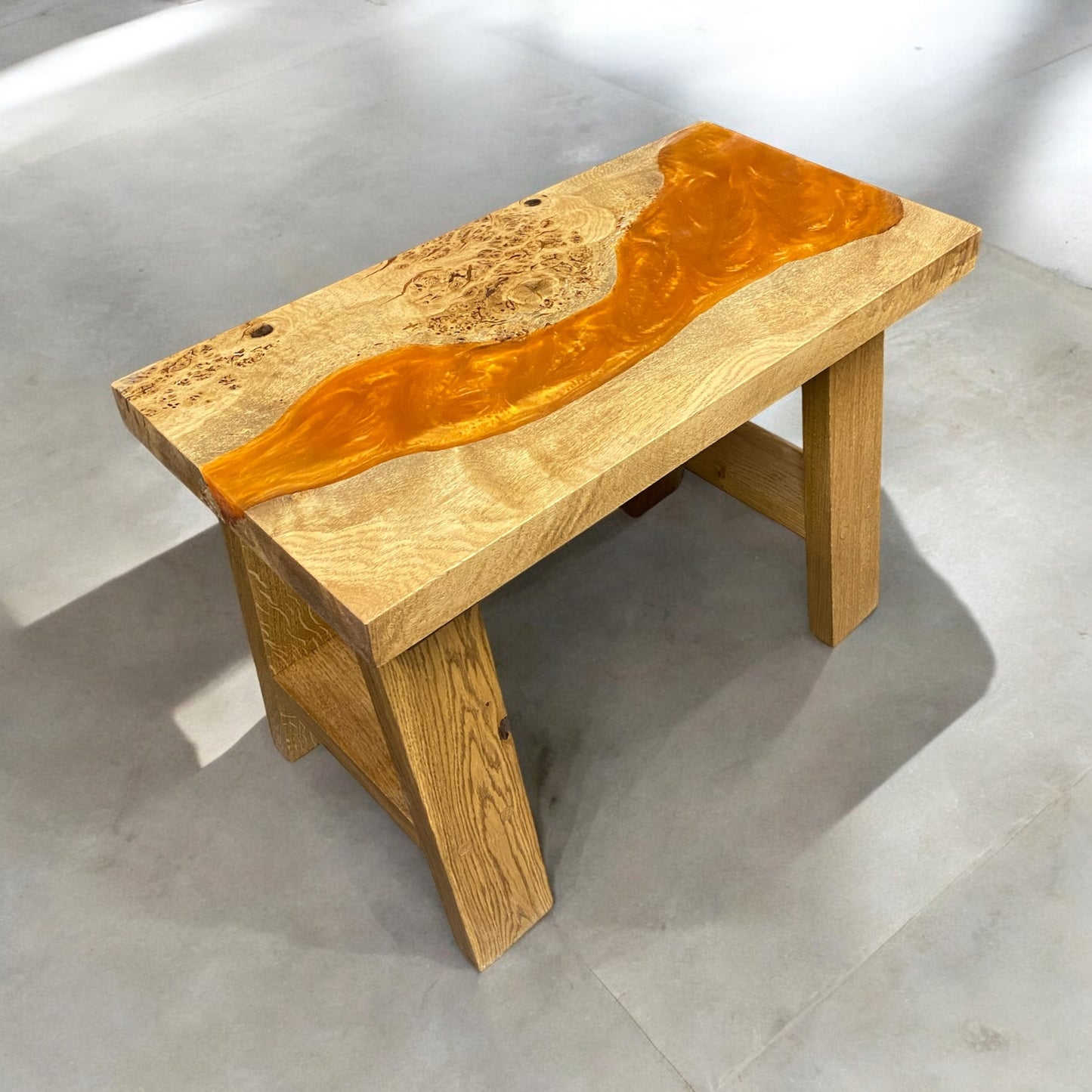 a photo of a live edge oak river table with orange resin and solid oak a frame legs