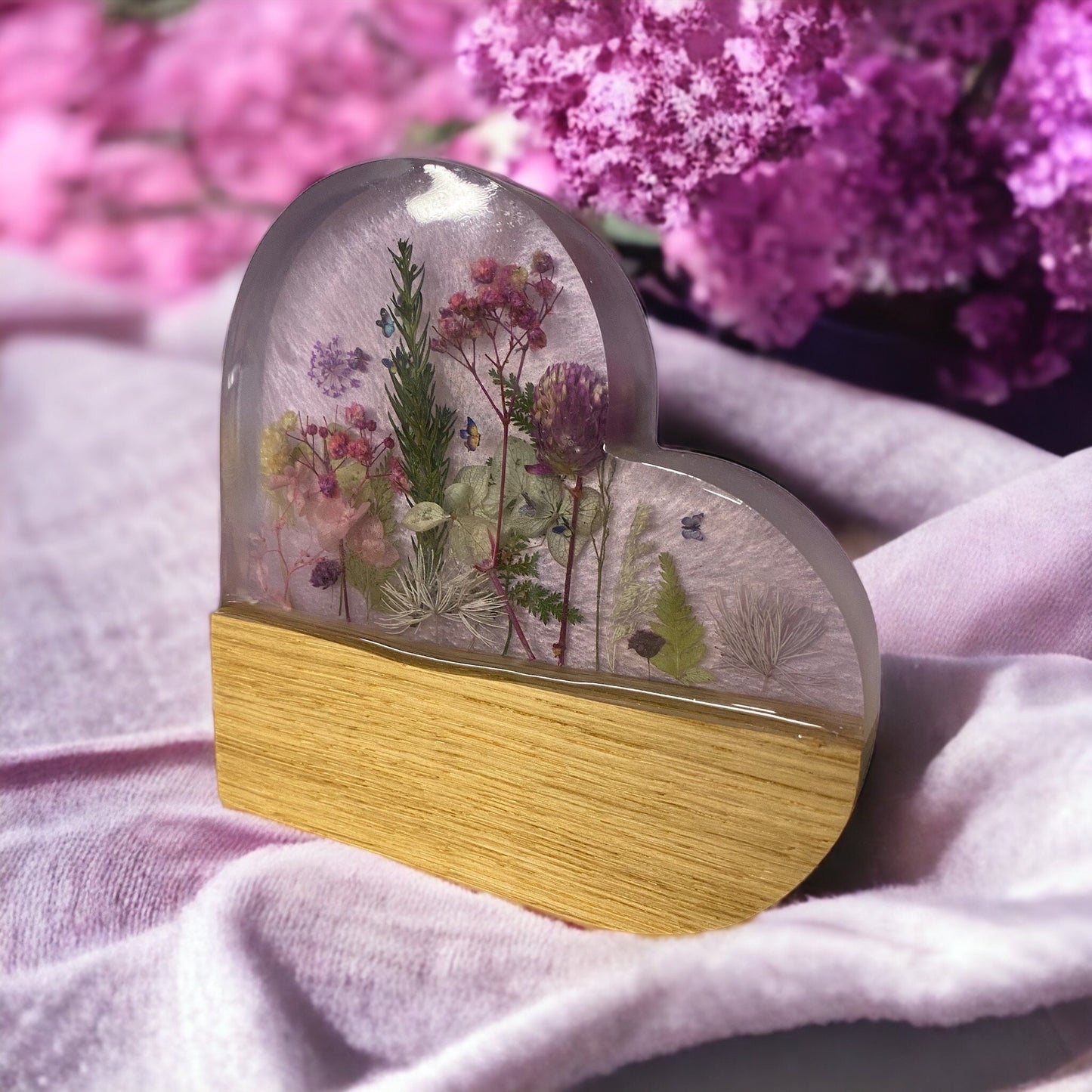 side view of a purple resin and oak heart shaped ornament with dried flower inlays